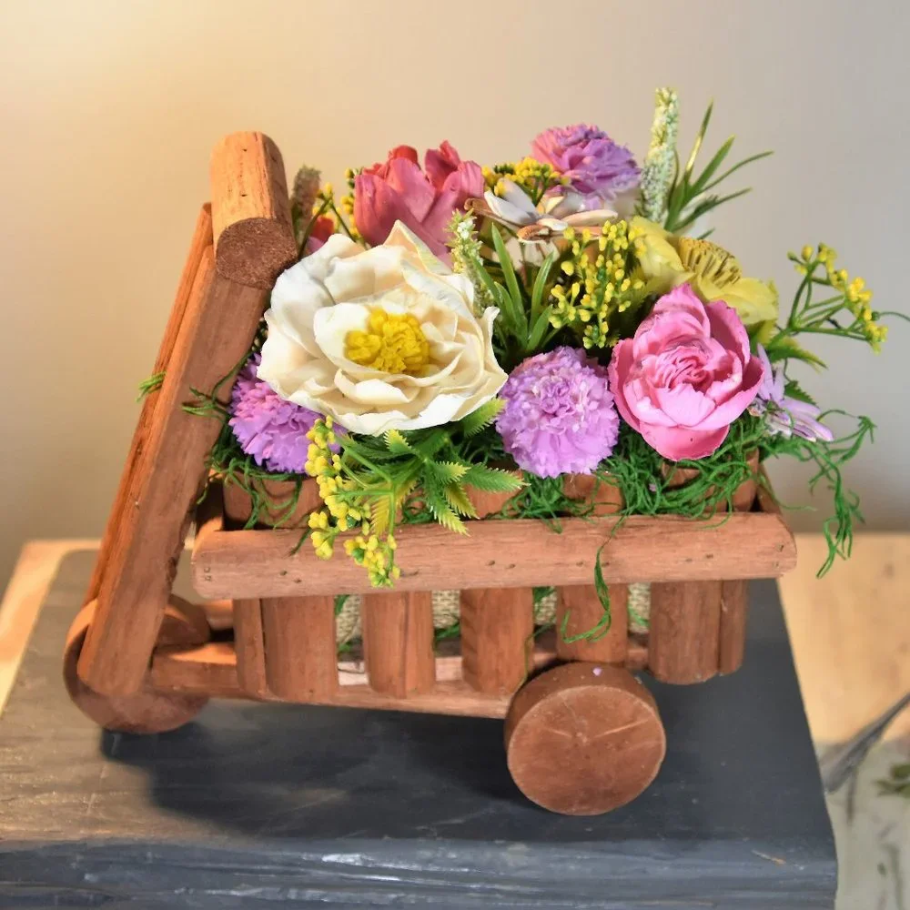 Cheerful garden arrangement of airbrushed Sola wood flowers in a garden cart